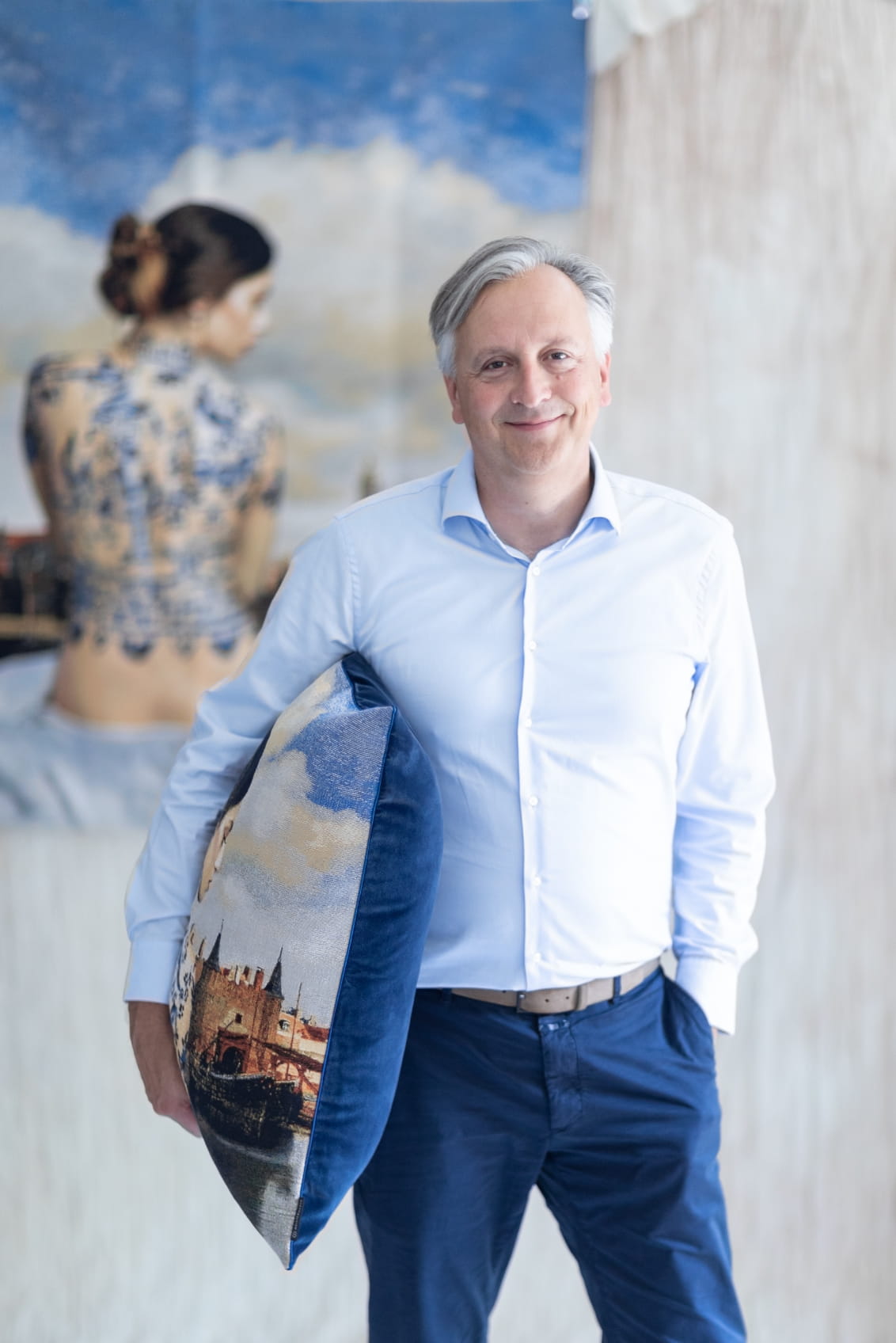 Christian Otto, Geschäftsführer der Die Stoffmacher GmbH in Weilheim an der Teck bei Stuttgart, steht im Showroom mit einem dekorativen Kissen und repräsentiert textile Kompetenz, Qualität und Erfahrung.